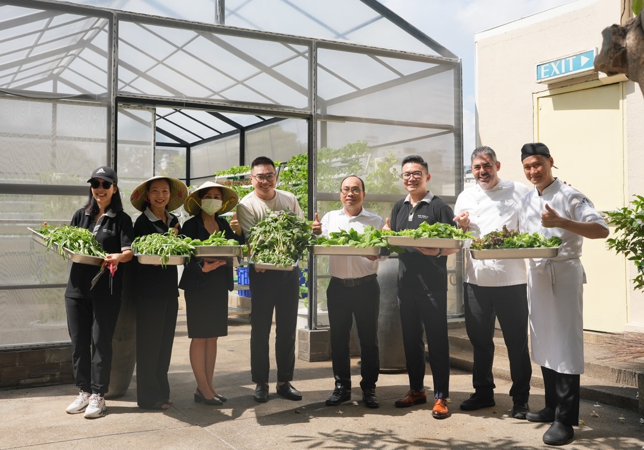 The team holding big platters of greenery at New World Saigon Hotel