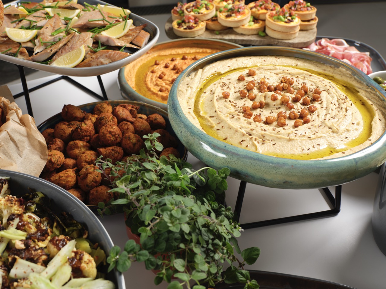 Healthy buffet options with hummus, roasted vegetables and poached salmon at Restaurant Associates