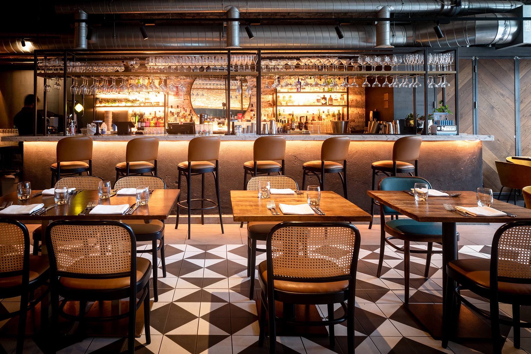 Restaurant interior with warm lighting and a bar counter in the background