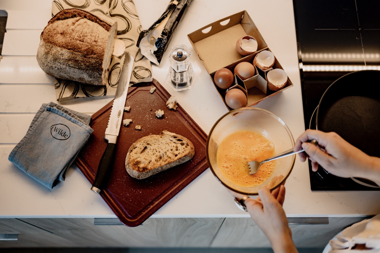 Overhead shot of someone making scrambled eggs and toast