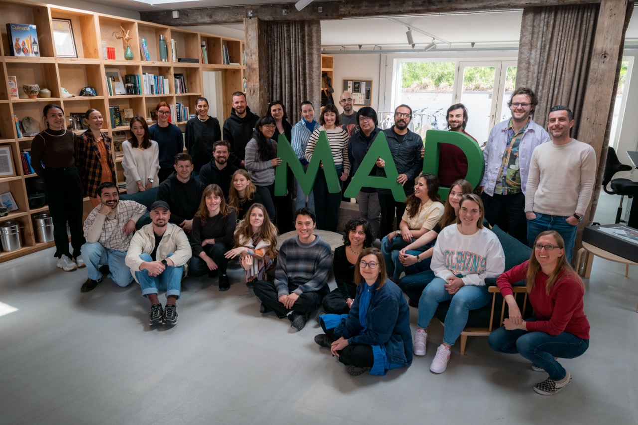 Group shot of people at MAD Academy holding giant letters spelling MAD