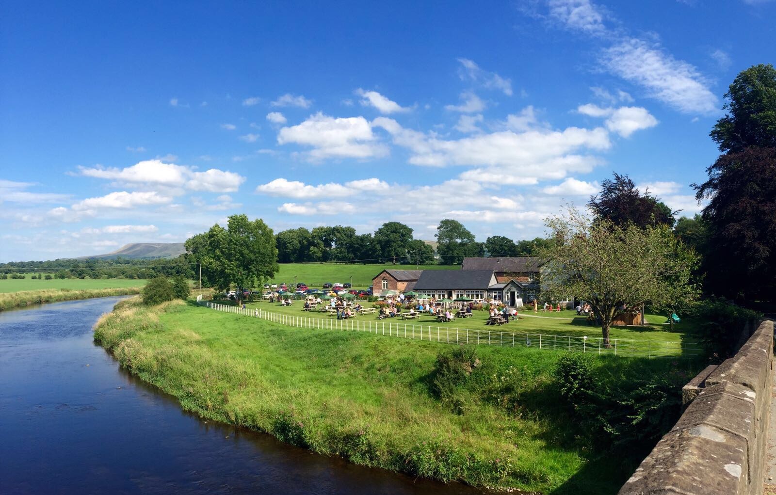 Exterior of Brunning & Price pub beside a river on a sunny day