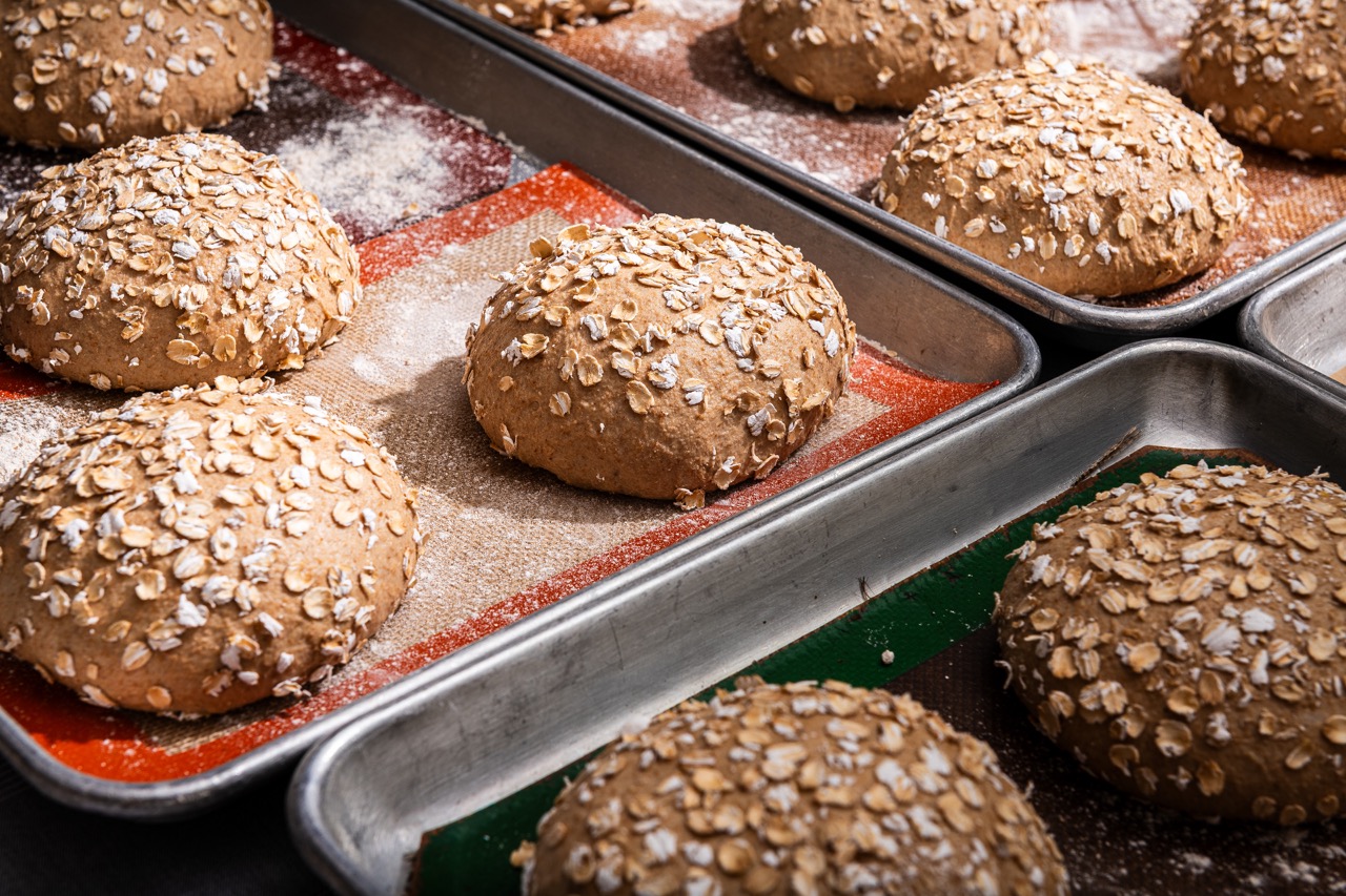 Bread rolls topped with oats, sitting on trays at Oyster Oyster, Washington DC