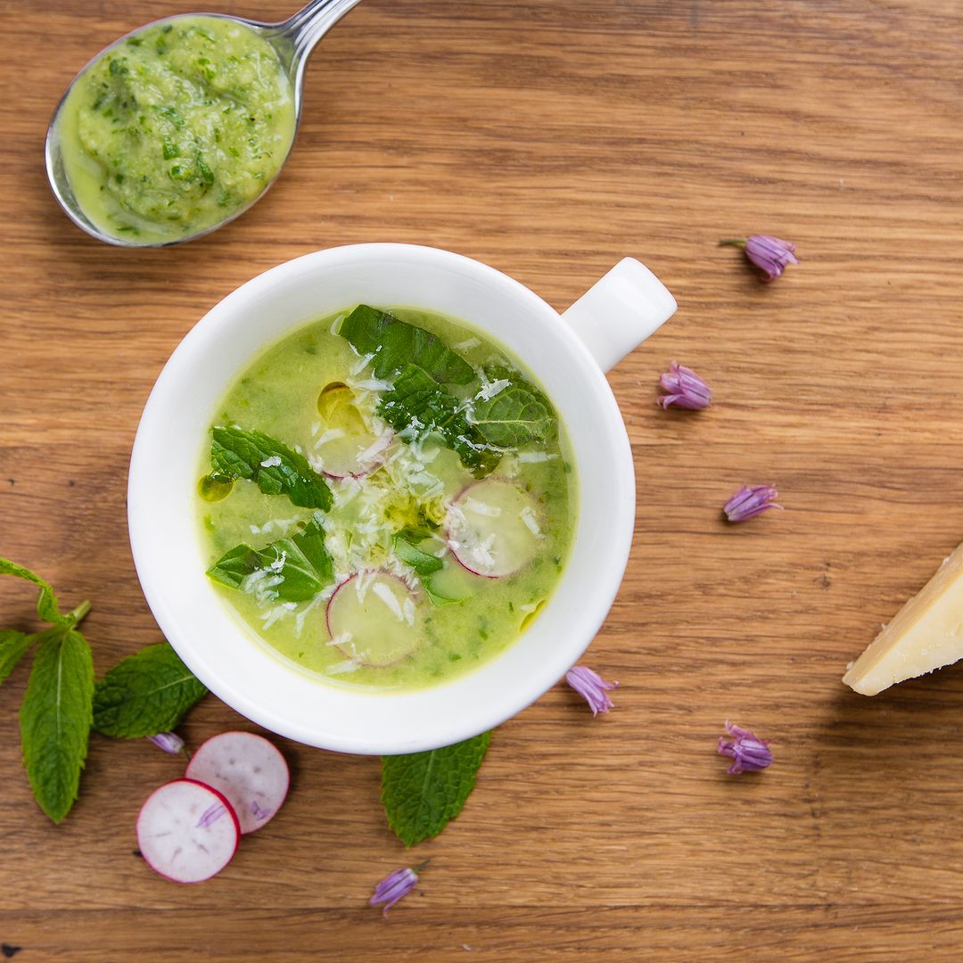 Overhead shot of white cup full of vibrant green soup at Café St Honore
