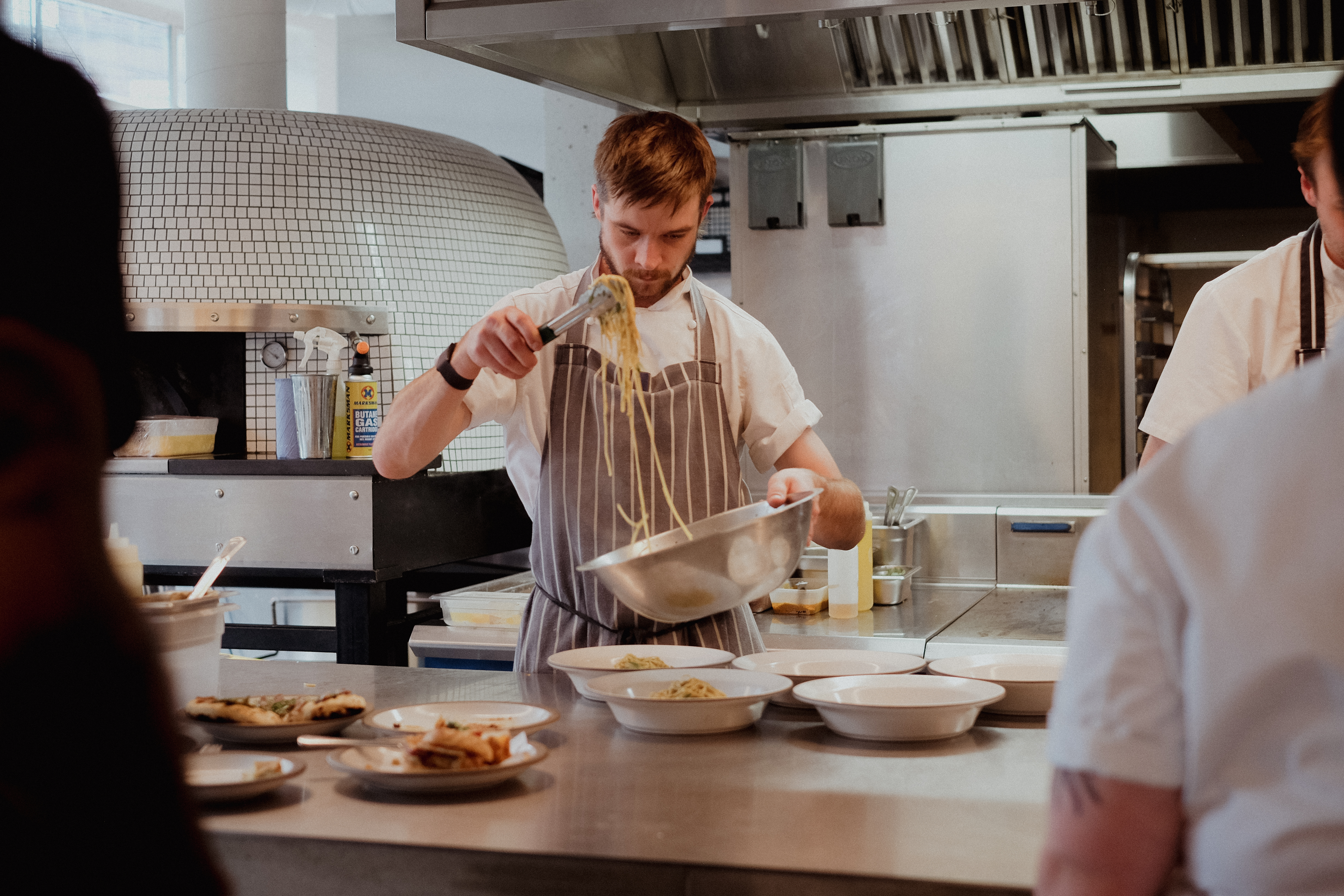 Chef wearing apron dishing up food at Ozone Coffee