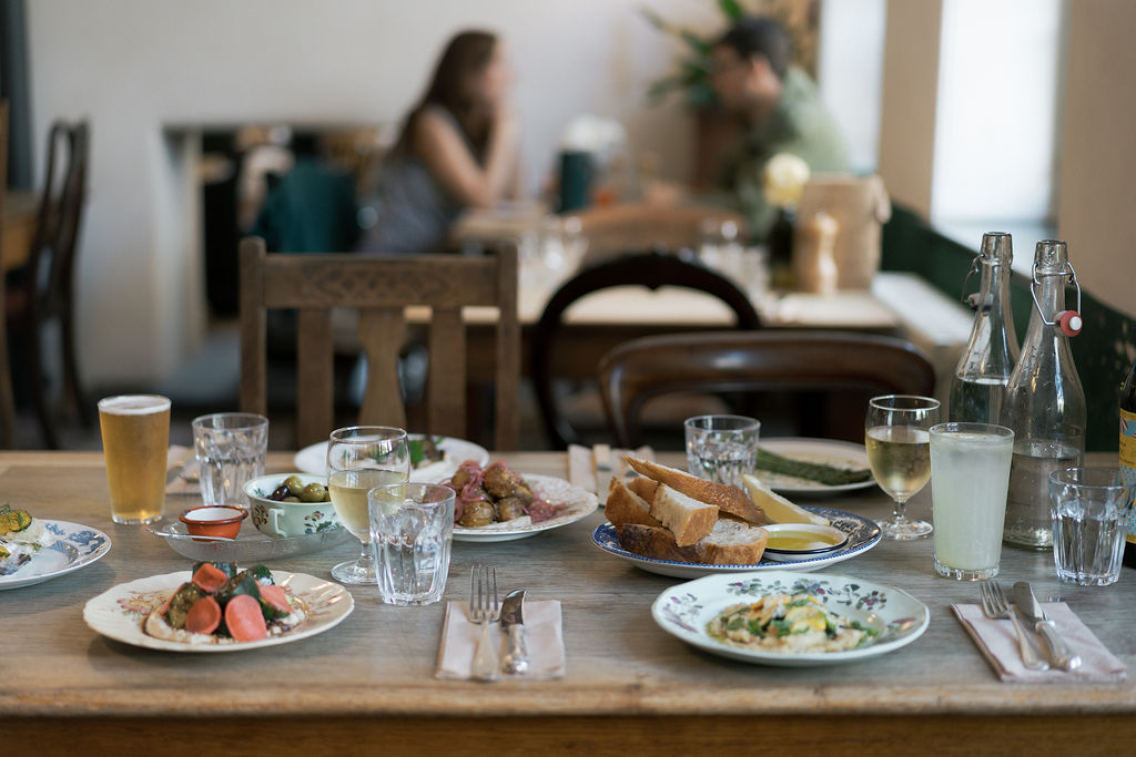 A table full of food at The Bull Inn, Totnes, with customers in background