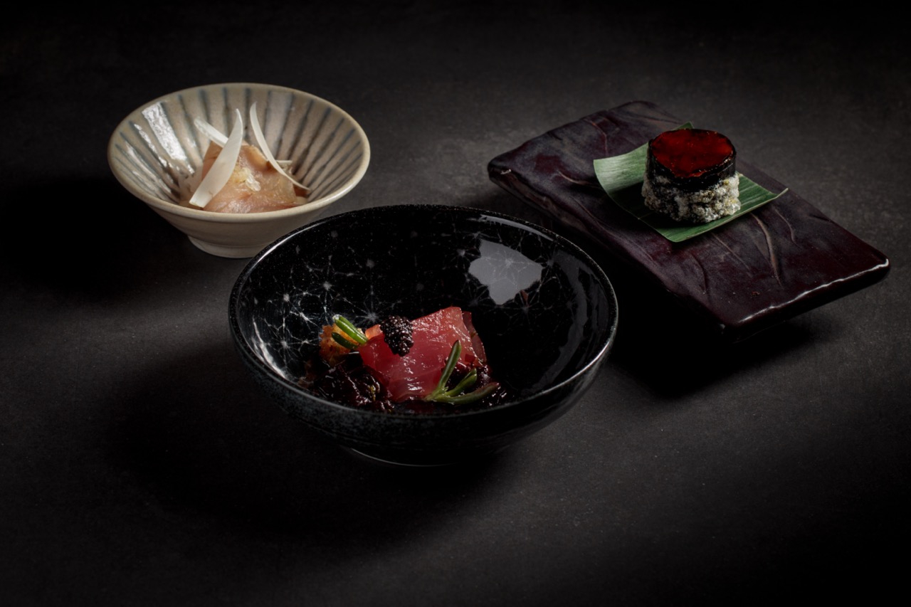 Beautiful food in black and white delph against dark background at FYN restaurant