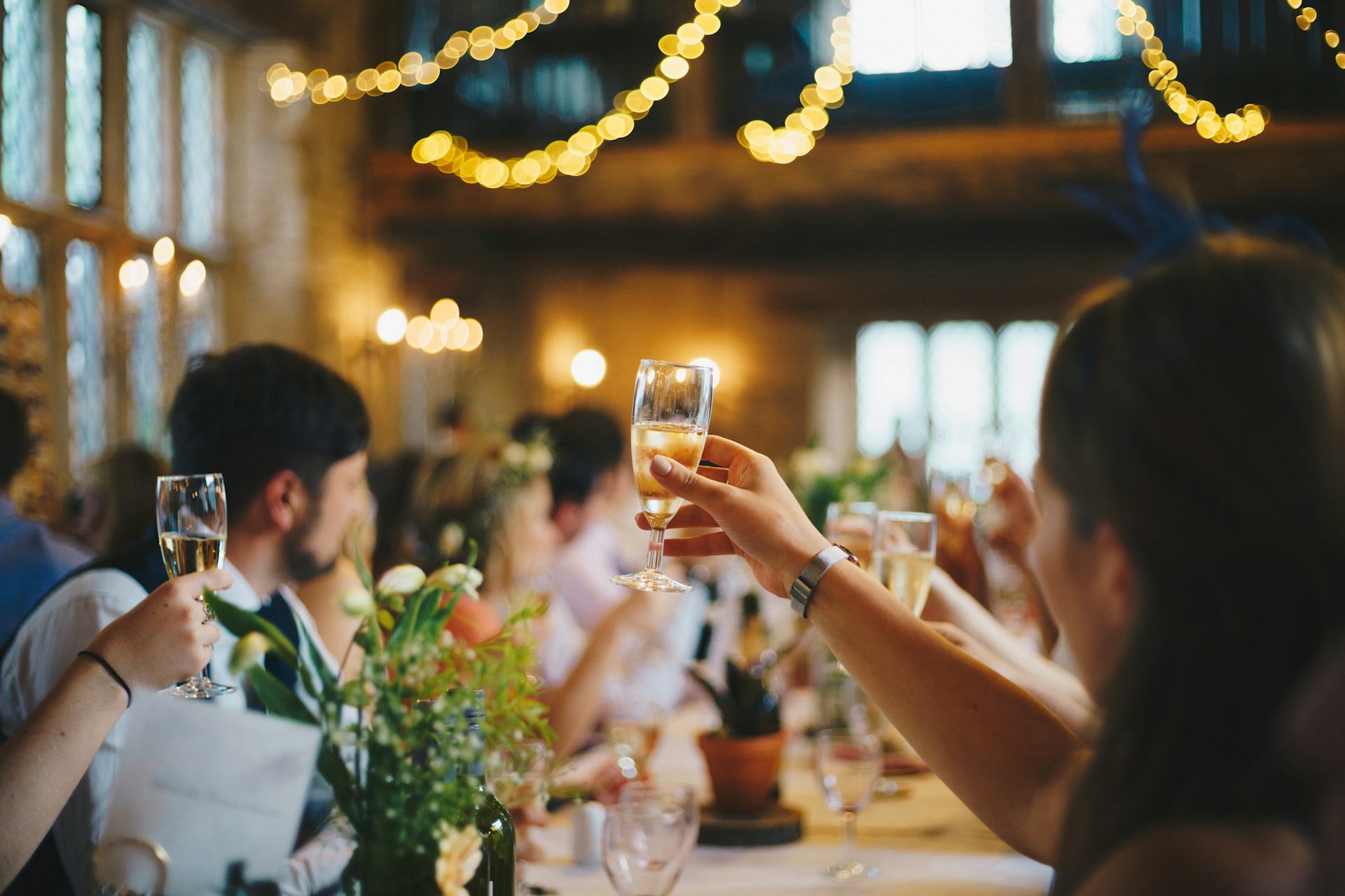People at a restaurant table raising their glasses for a toast