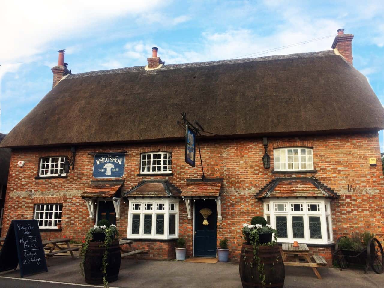 Exterior shot of Wheatsheaf pub – a red brick building with thatched roof