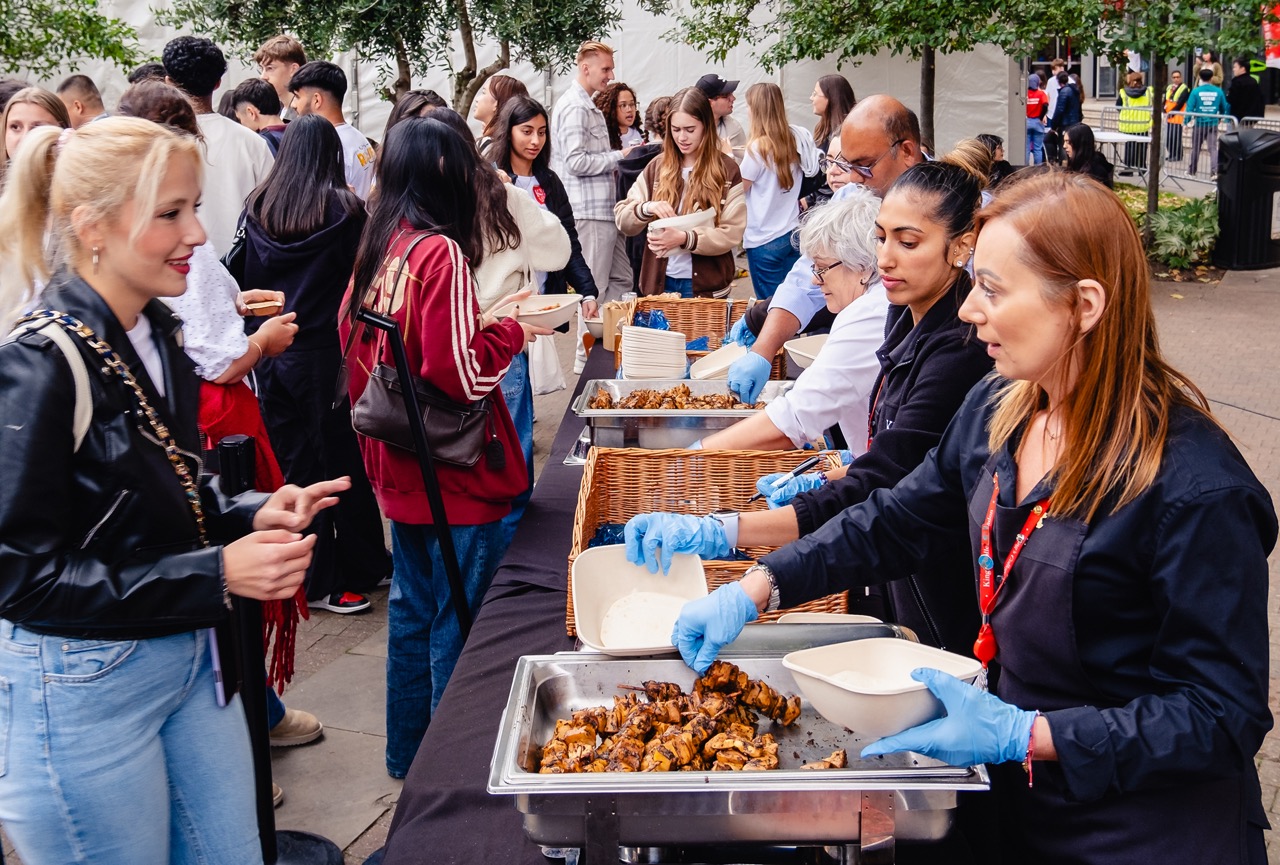 Students being served plant-based dishes outdoors at King's College London