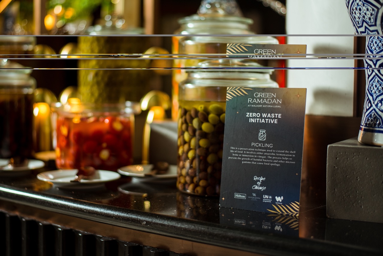 Small sign at breakfast buffet explaining Hilton zero waste initiatives