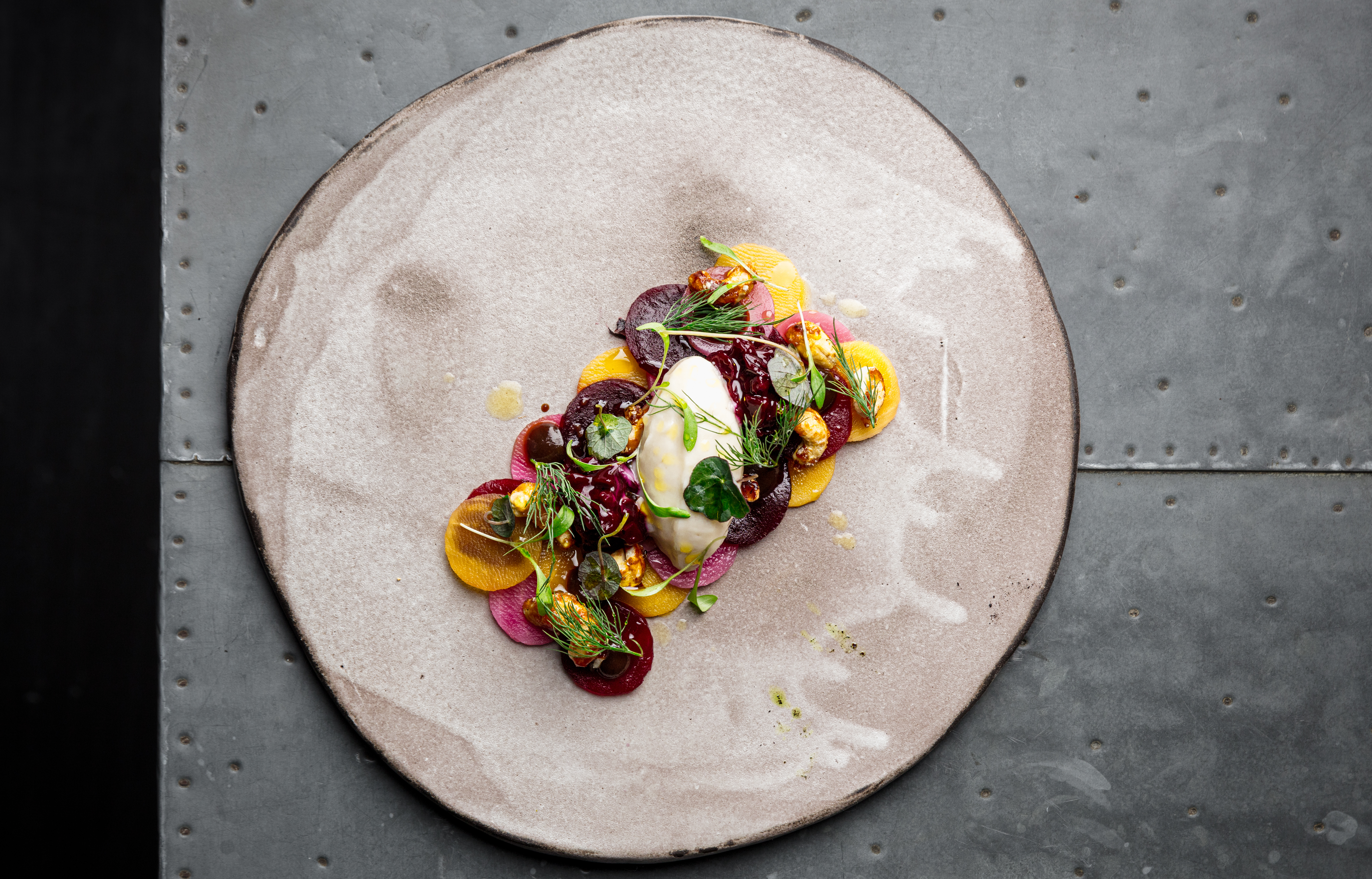 Beautiful food on grey plate against metal background