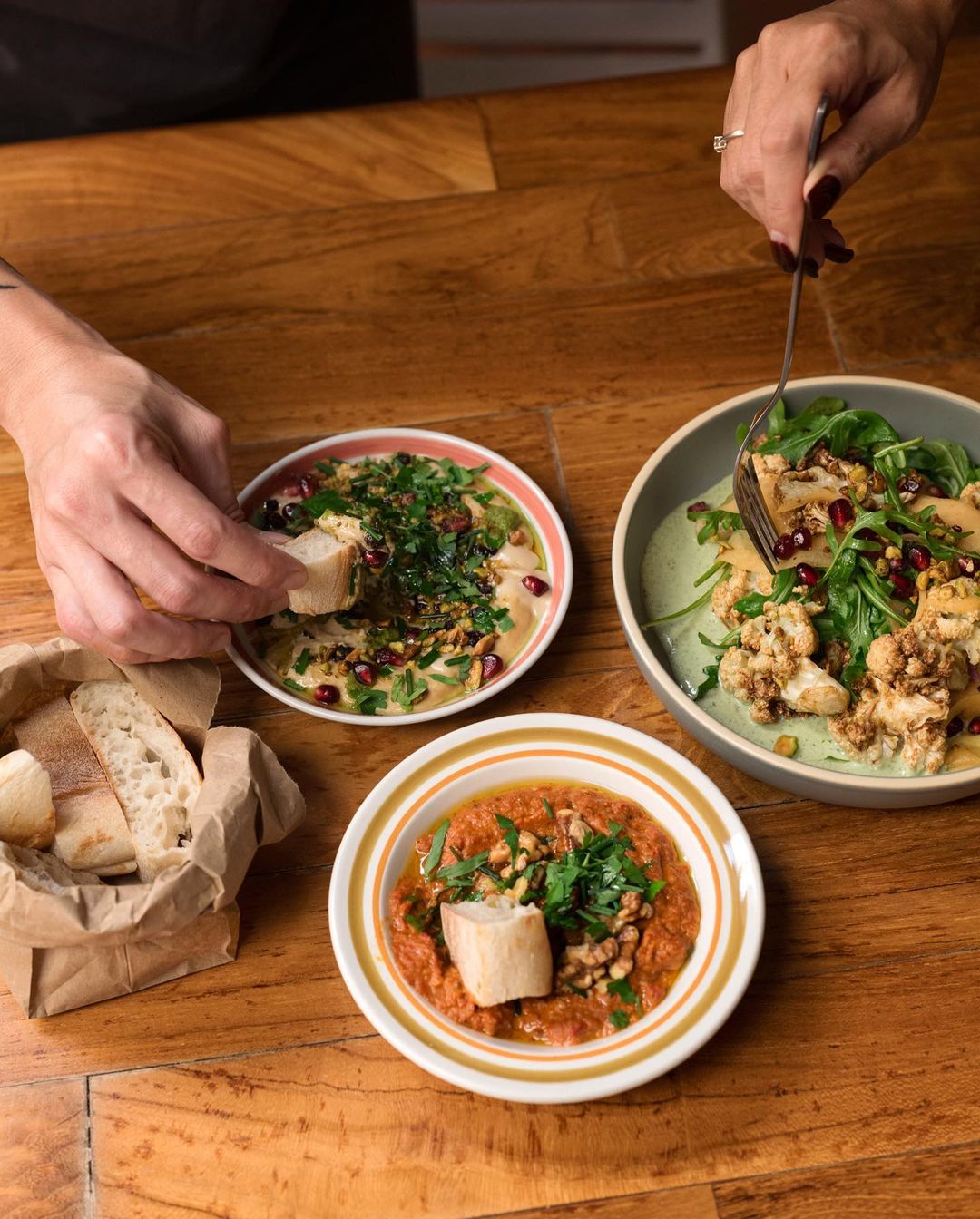 Hands eating selection of vegetarian food