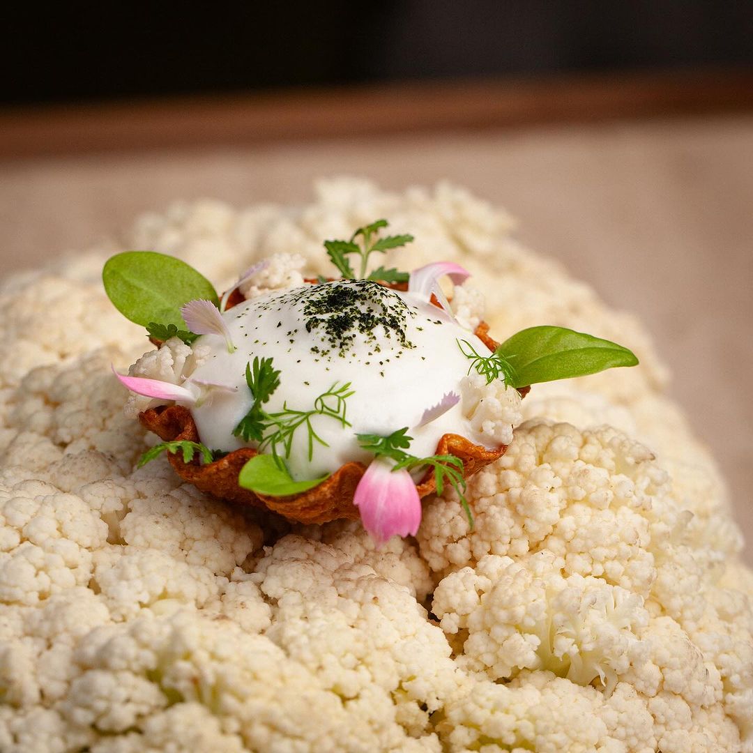 Tiny portion of beautiful food presented on head of cauliflower