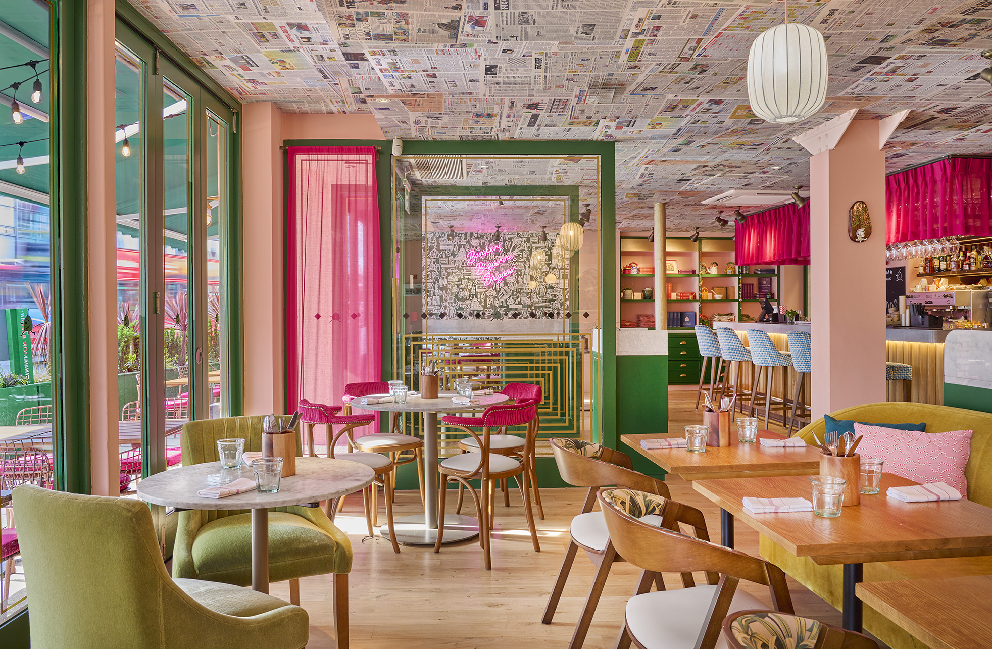 Restaurant interior with pink decor, brightly lit from window on the left