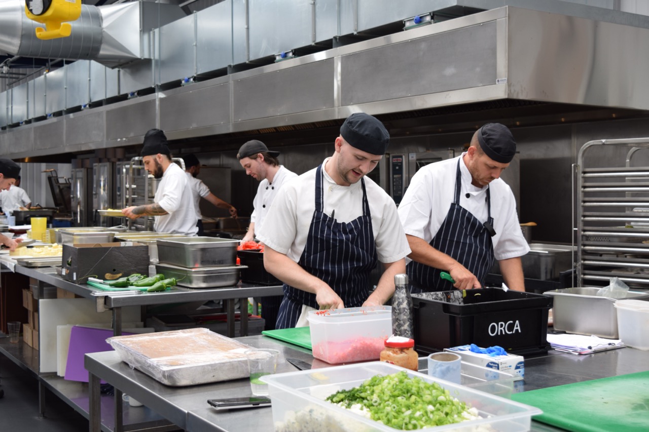 Chefs working in kitchen at Fooditude