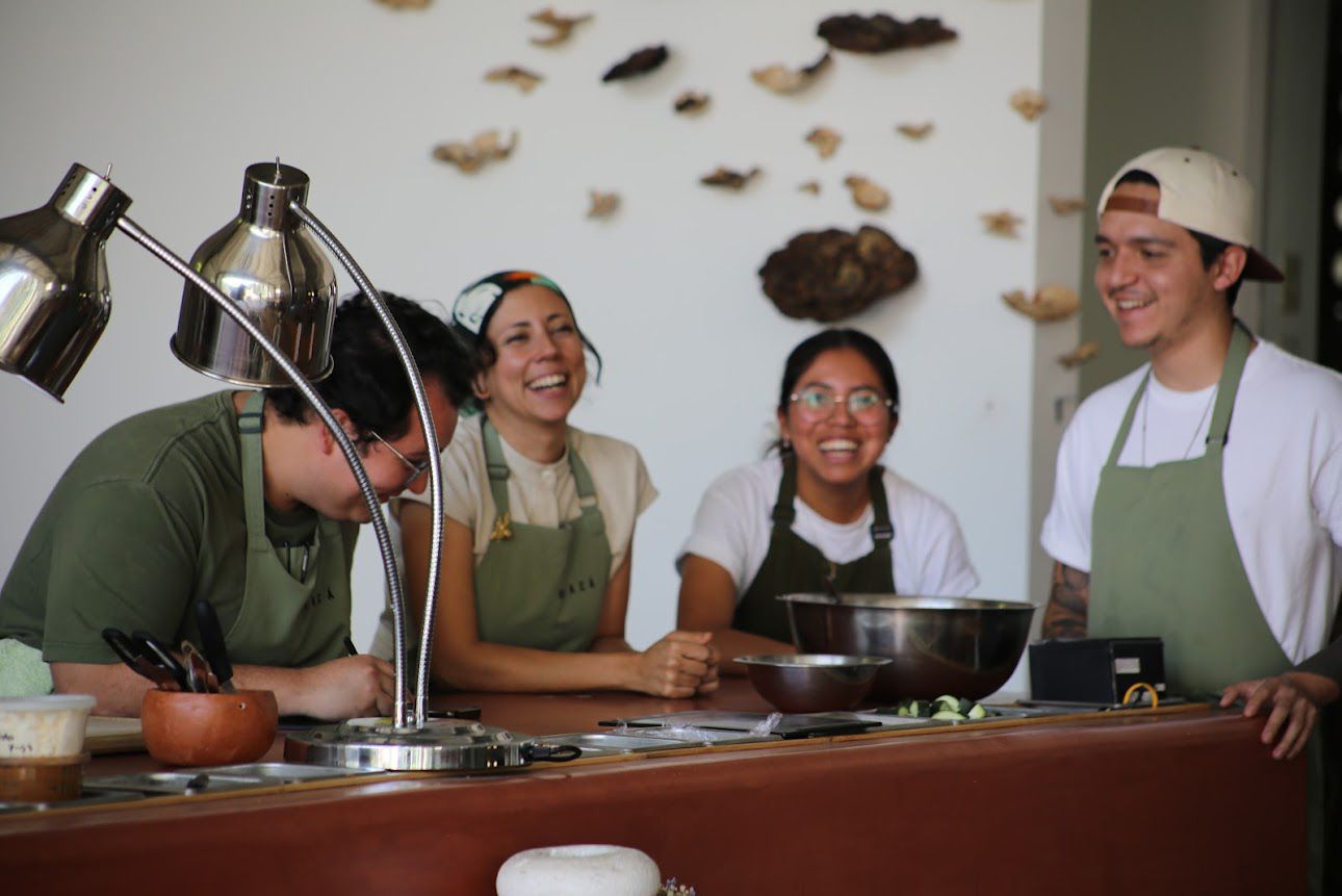 Chef Debora Fadul laughing with three team members in kitchen