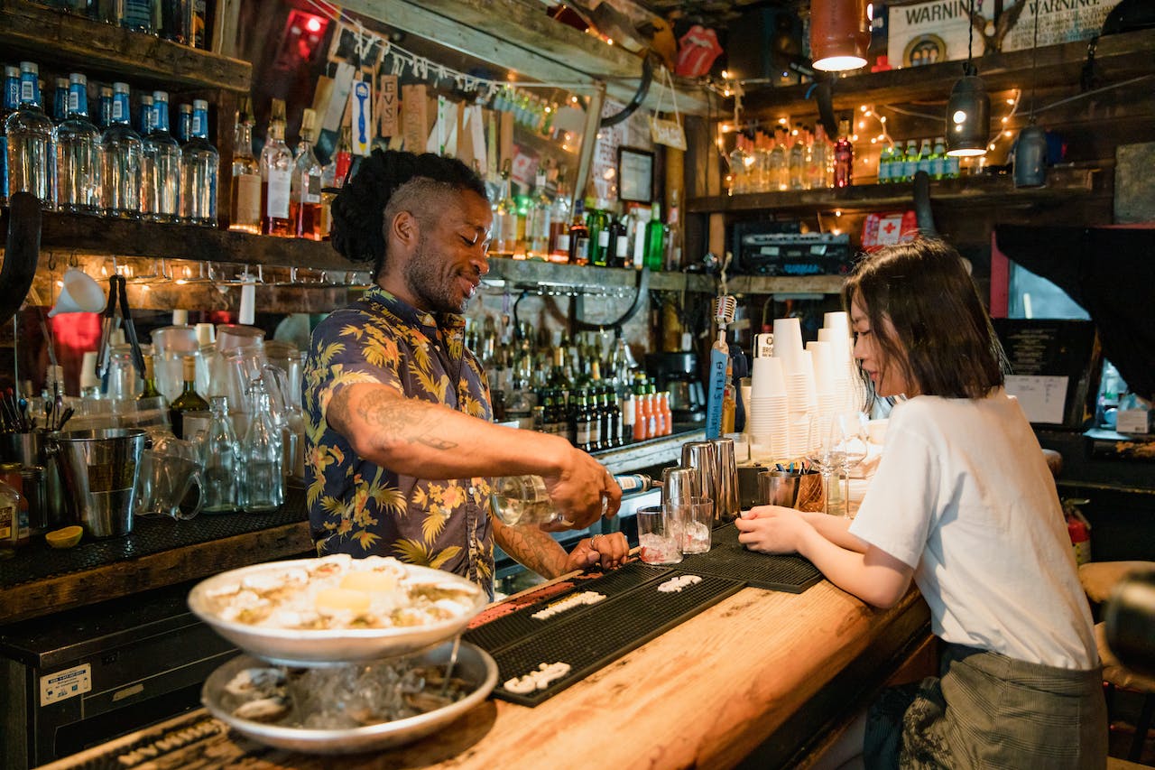 Bartender serving customer in dark bar