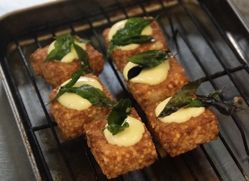 Golden fried snacks topped with yellow and green sauces at The Salopian Inn