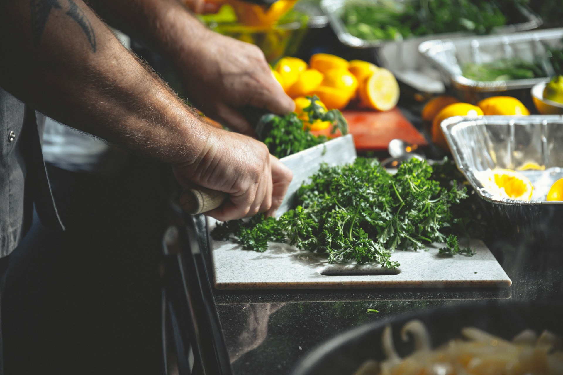 Chef's hand chopping parsley