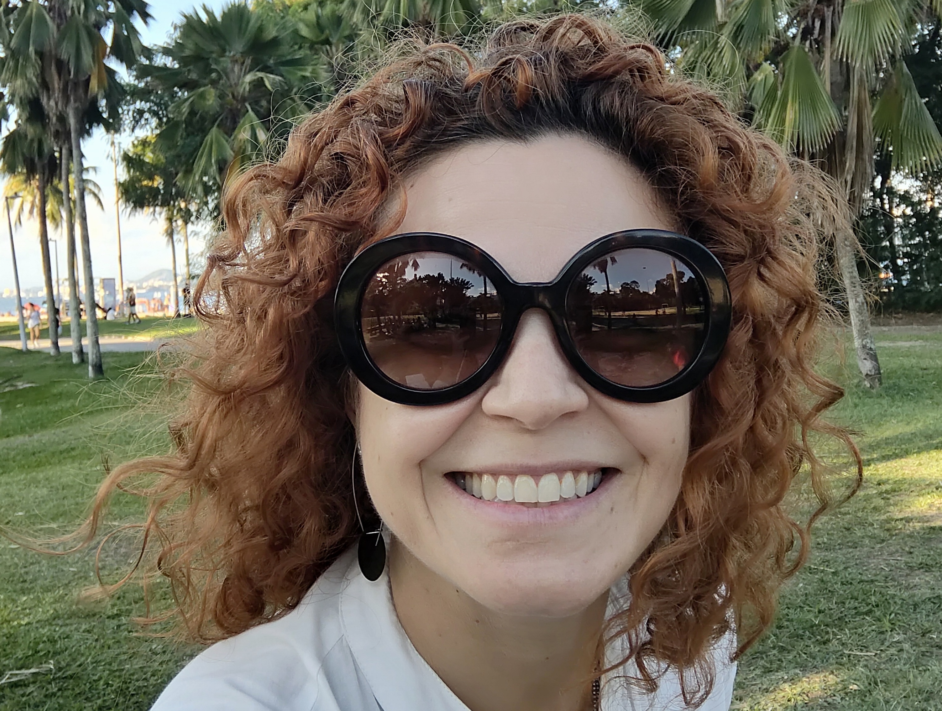 Ellen Gonzalez wearing sunglasses in a park, with palm tress in the background