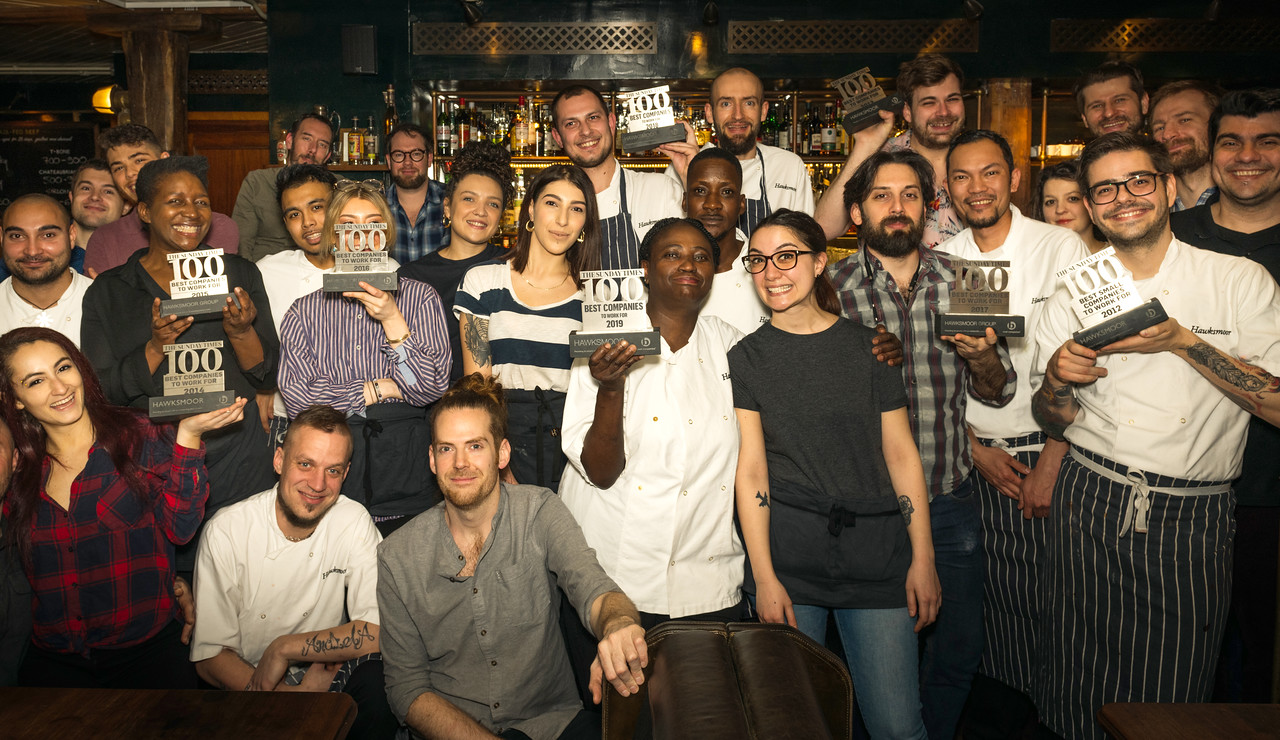 A group of Hawksmoor employees celebrating "100 best companies to work for" awards