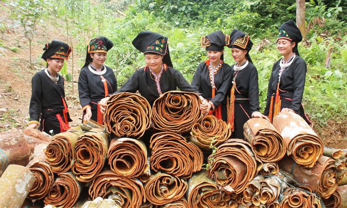 Spice producers in black and red garments standing behind table
