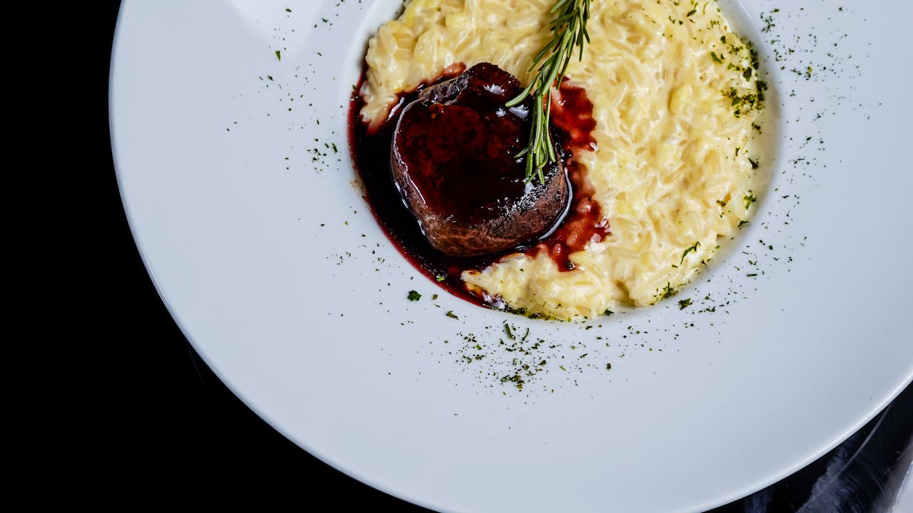 Overhead shot of beef in a dark red sauce with risotto