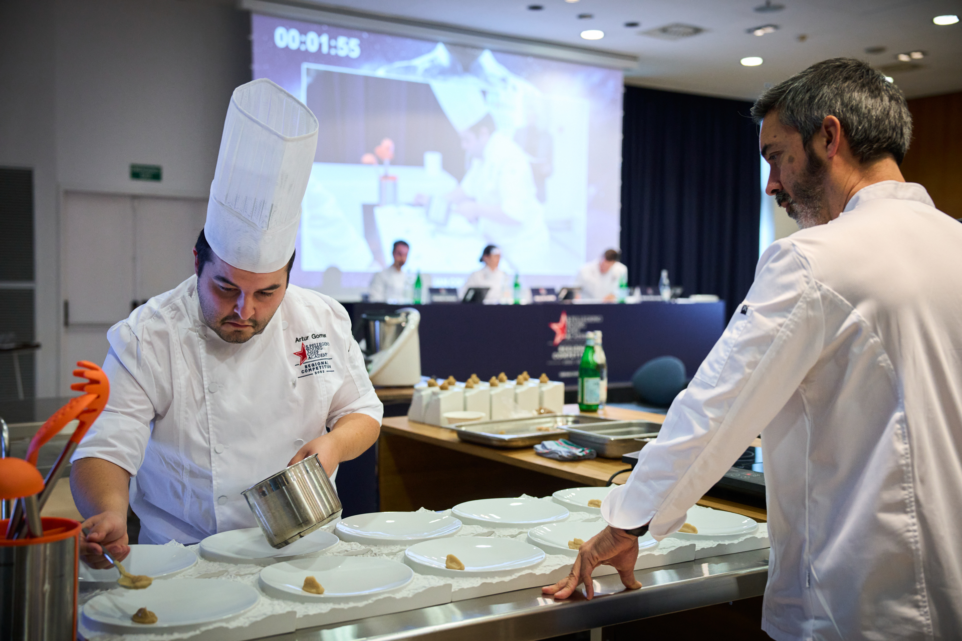 Chef in tall hat and white jacket prepping food