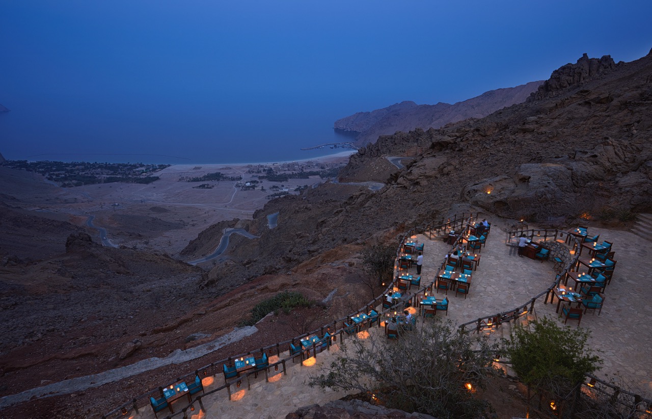 Candlelit tables on terraces overlooking the ocean at Six Senses Zighy Bay