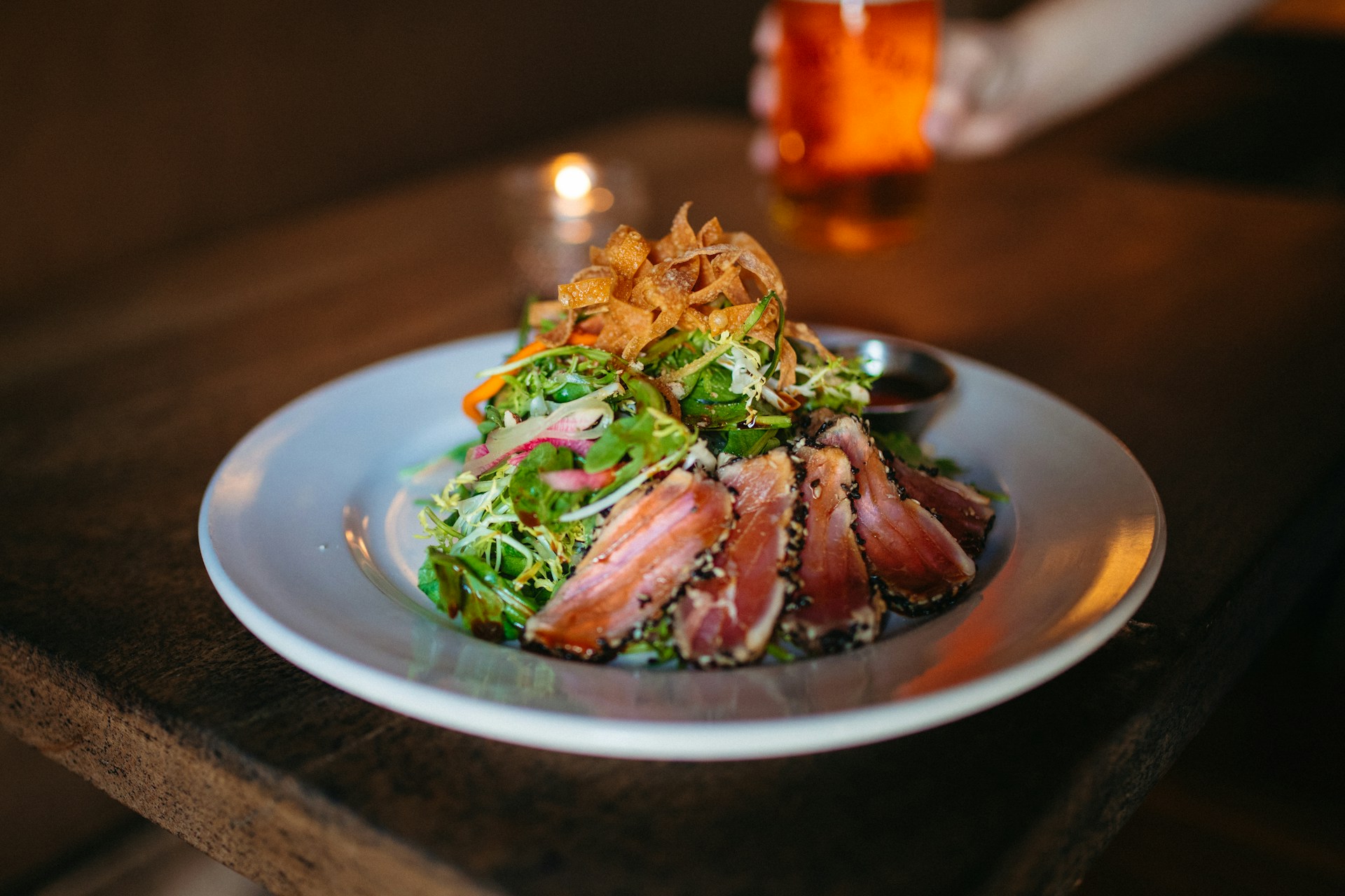 Seared tuna salad in white bowl on table