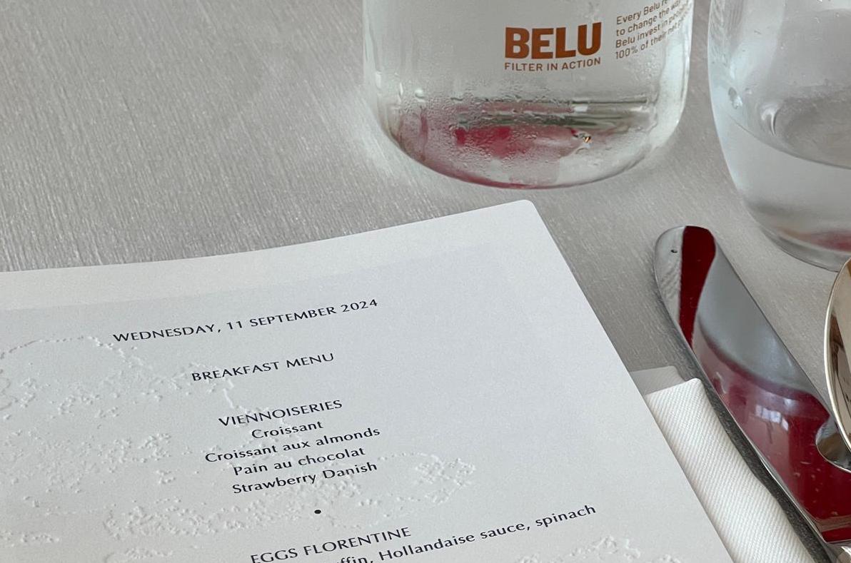 Breakfast menu and Belu water bottle at 'Small Changes, Big Impact: Driving Sustainability Through Hospitality', a free resource from Belu and The Sustainable Restaurant Association