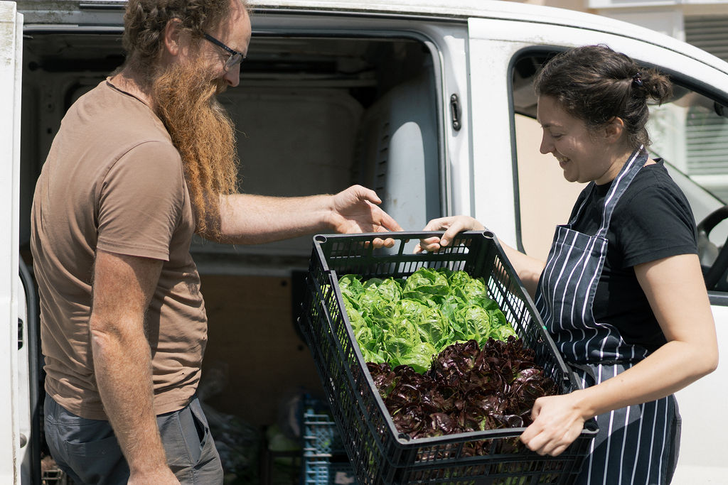 A chef taking a delivery of vegetables from a supplier outside The Bull Inn, Totnes