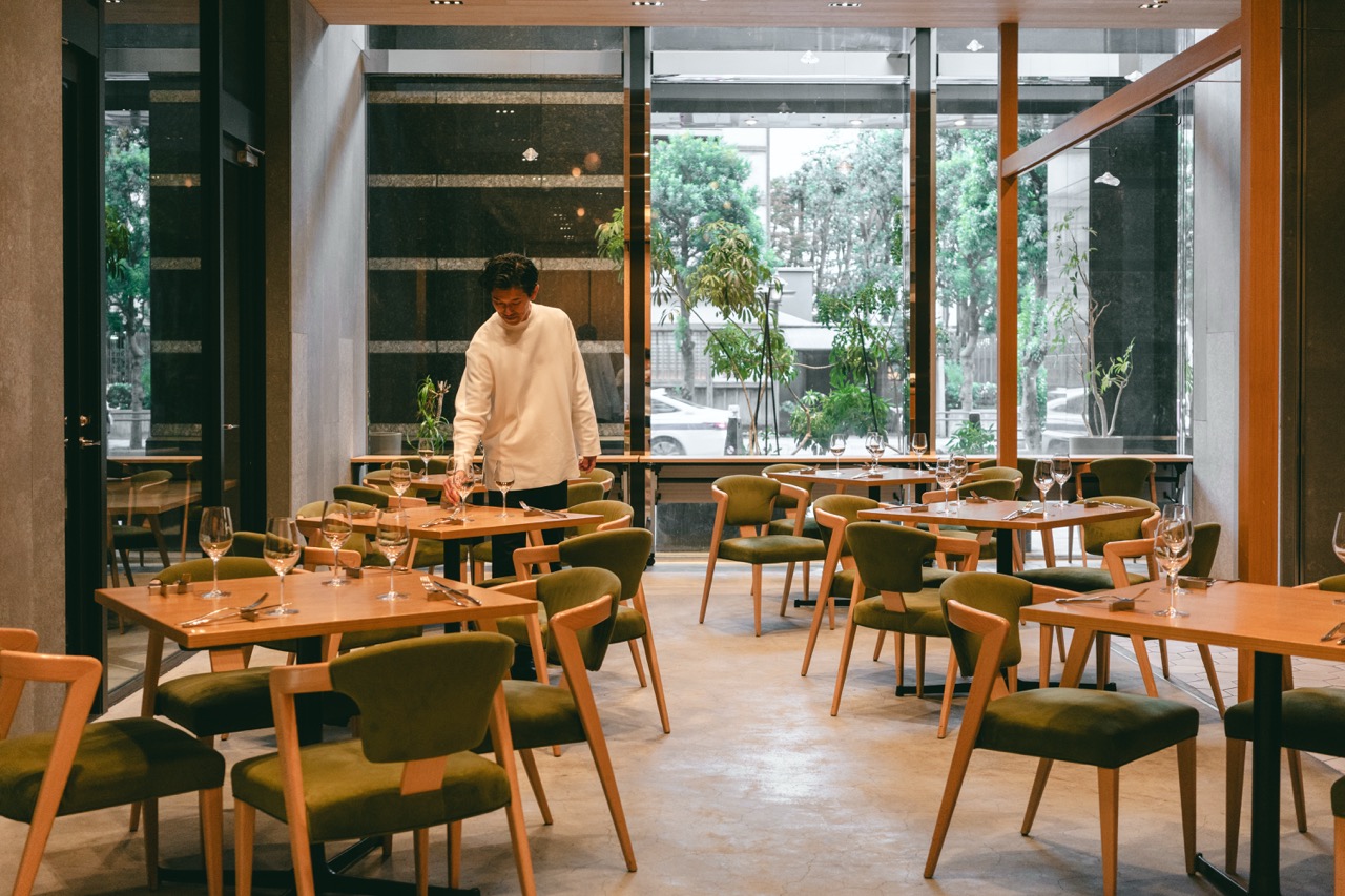 Interior of KIGI restaurant, Tokyo, with a staff member setting tables