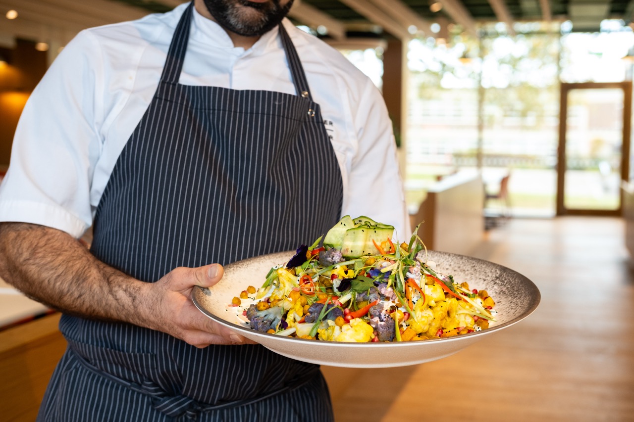 A male chef holding a plate of beautiful salad at Gather + Gather Ireland