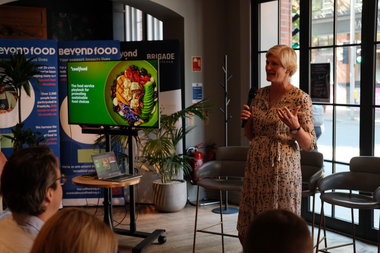Edwina Hughes from WRI Coolfood speaking into a microphone at the Rethinking the Menu event