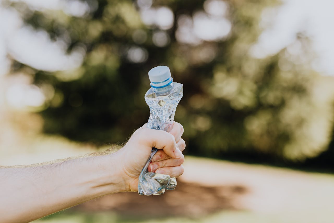 plastic bottle being crushed in hand