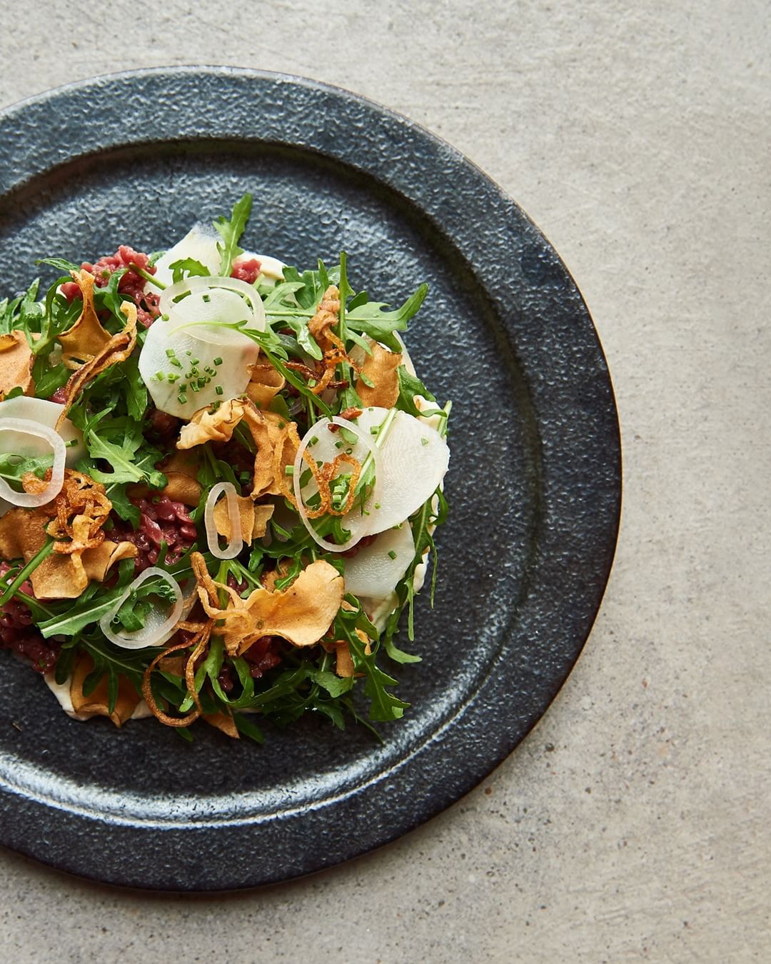 Beautiful salad dish on black plate, shot from overhead