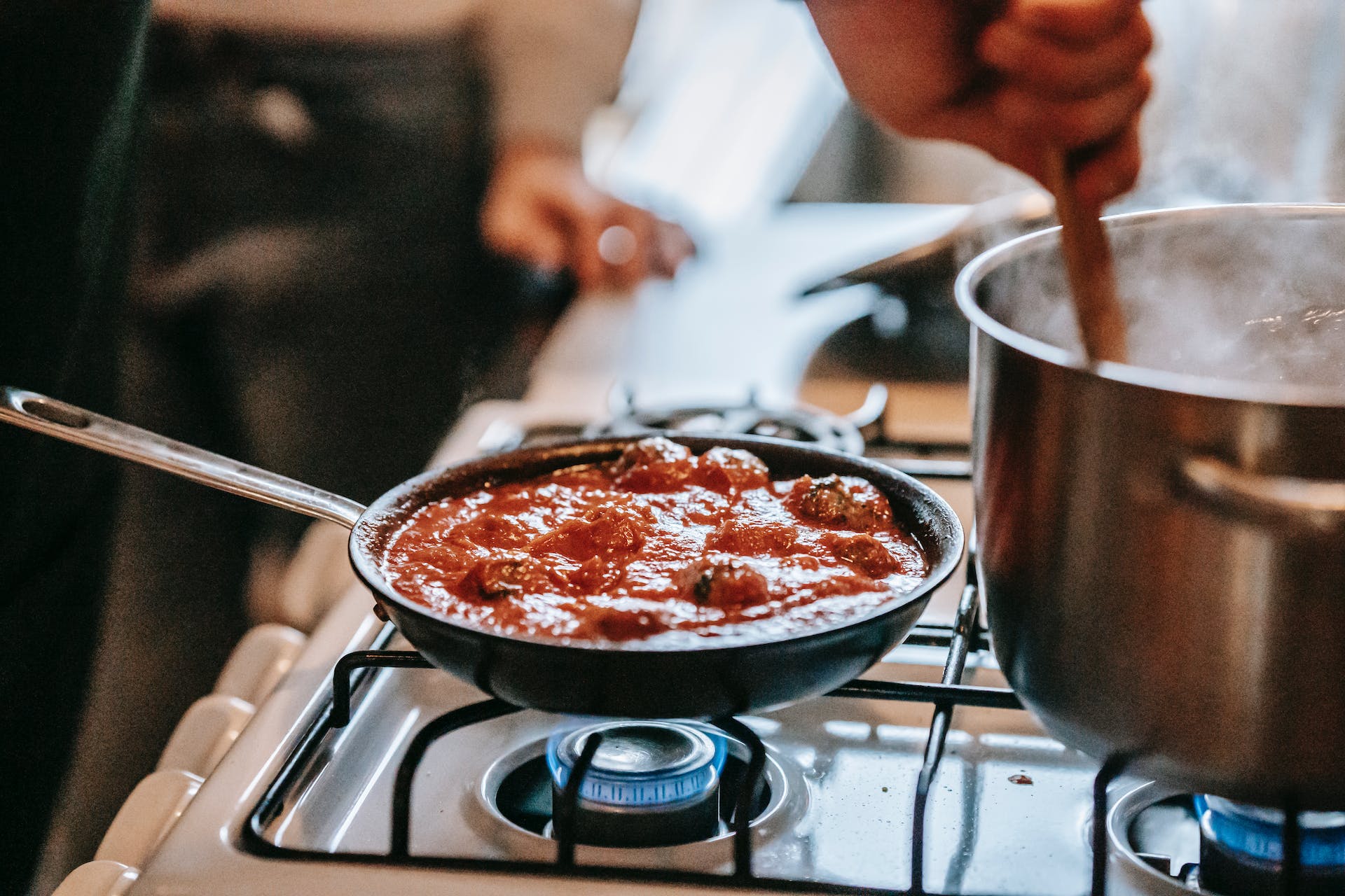 Meatballs simmering in tomato sauce in cast iron skillet