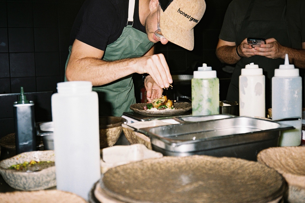 A chef seasoning a dish at Honest Greens
