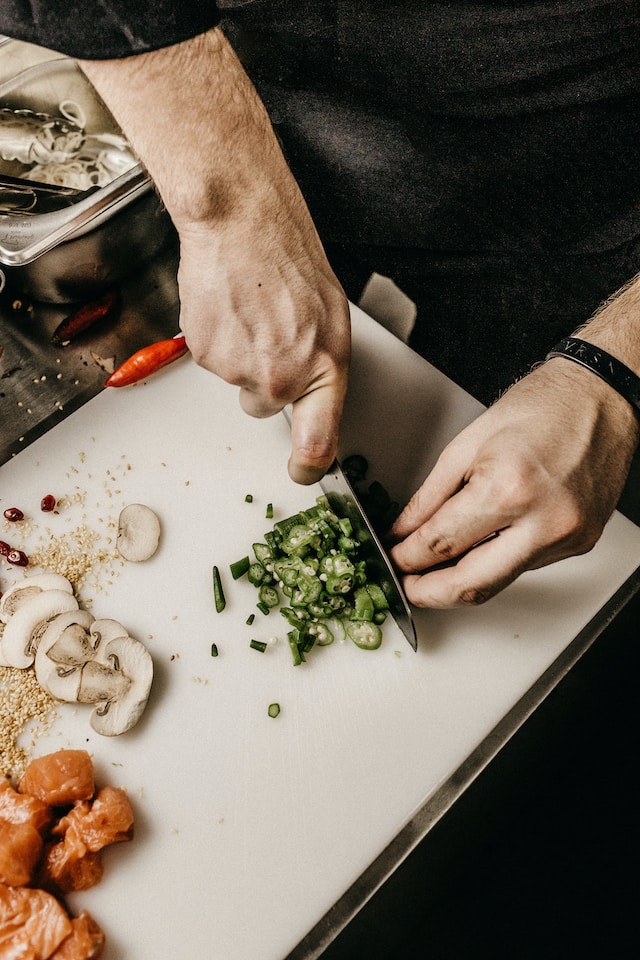 Chef hands chopping herbs with knife