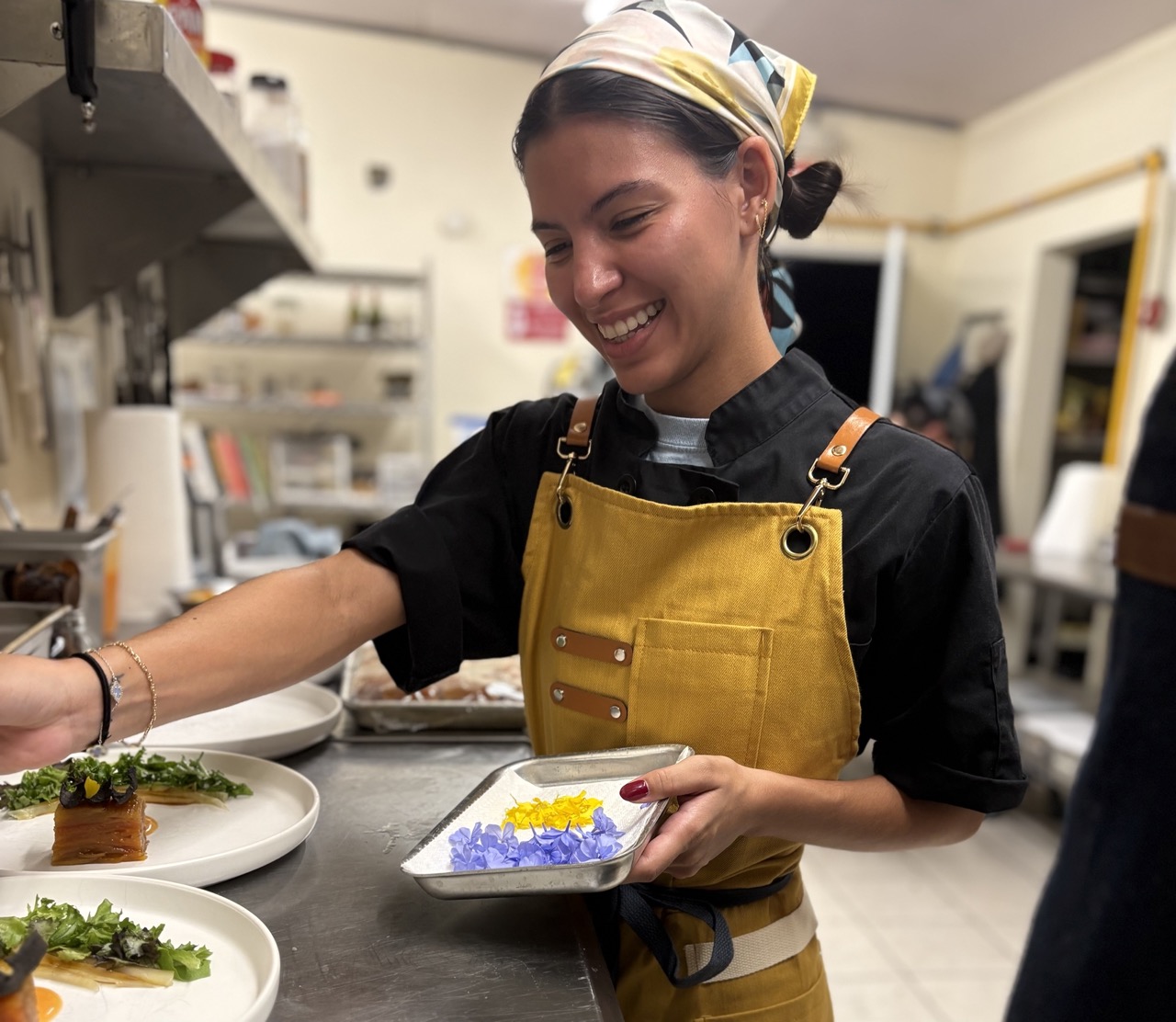 Smiling kitchen staff assembling dishes at Chef's Garden Puerto Rico