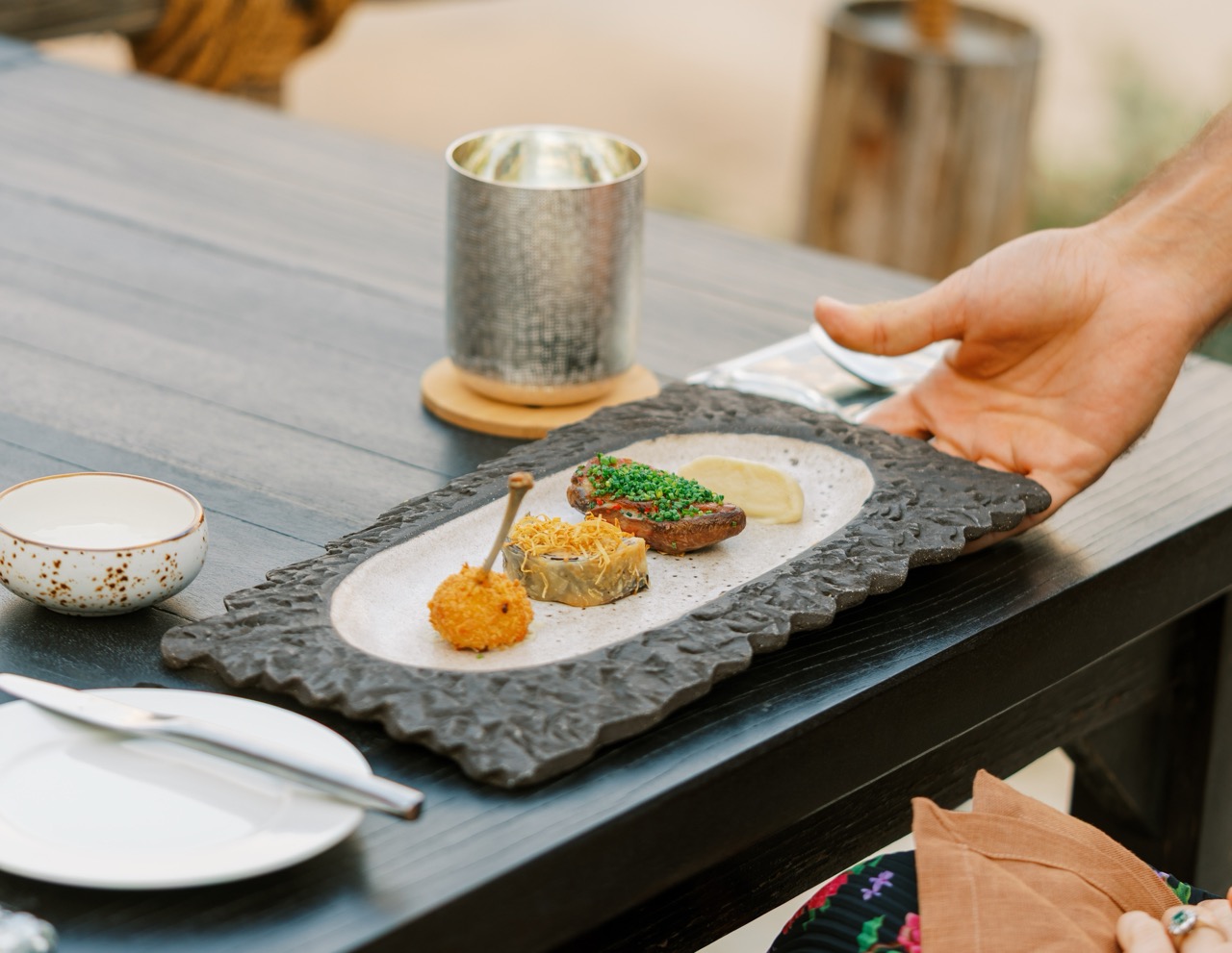 A plate of food being served outdoors at Six Senses Zighy Bay