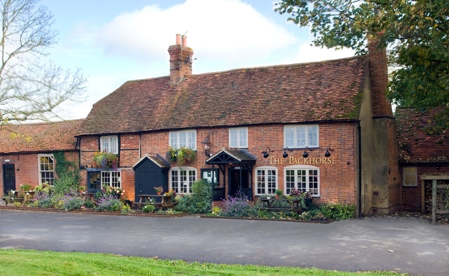 Exterior shot of a pub with red brick walls and a sign saying "The Packhorse"