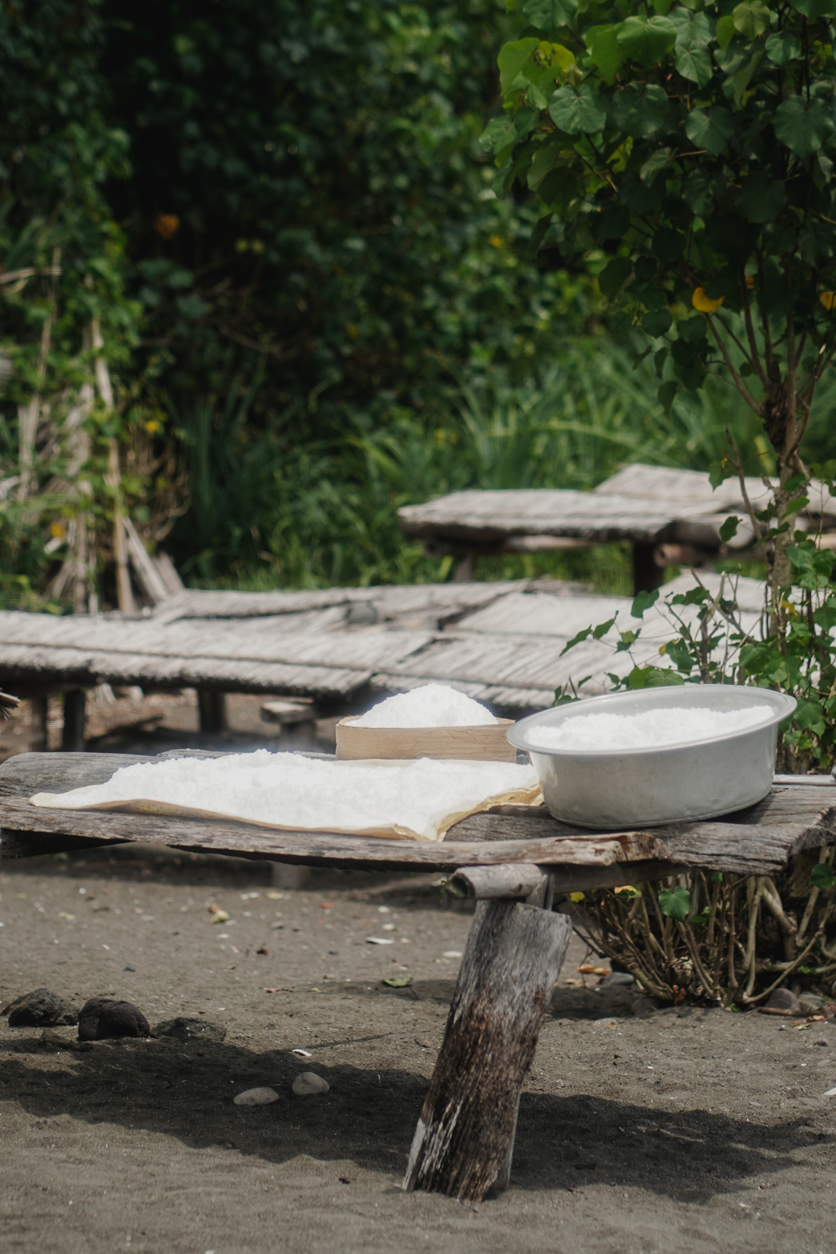 Salt in tubs and on sheets, on wooden tables on Balinese beach