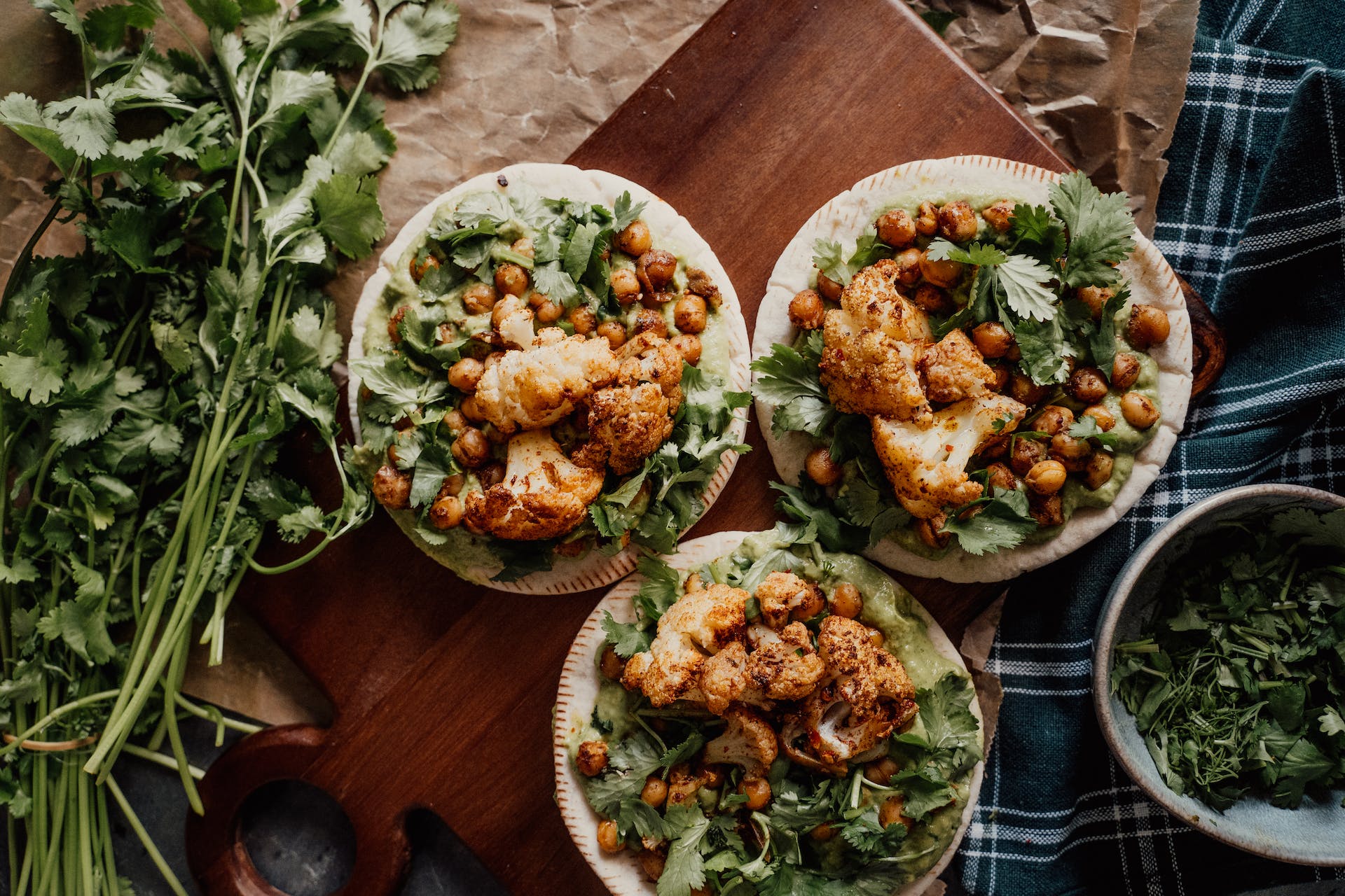 Overhead shot of three flatbreads with cauliflower and chickpeas