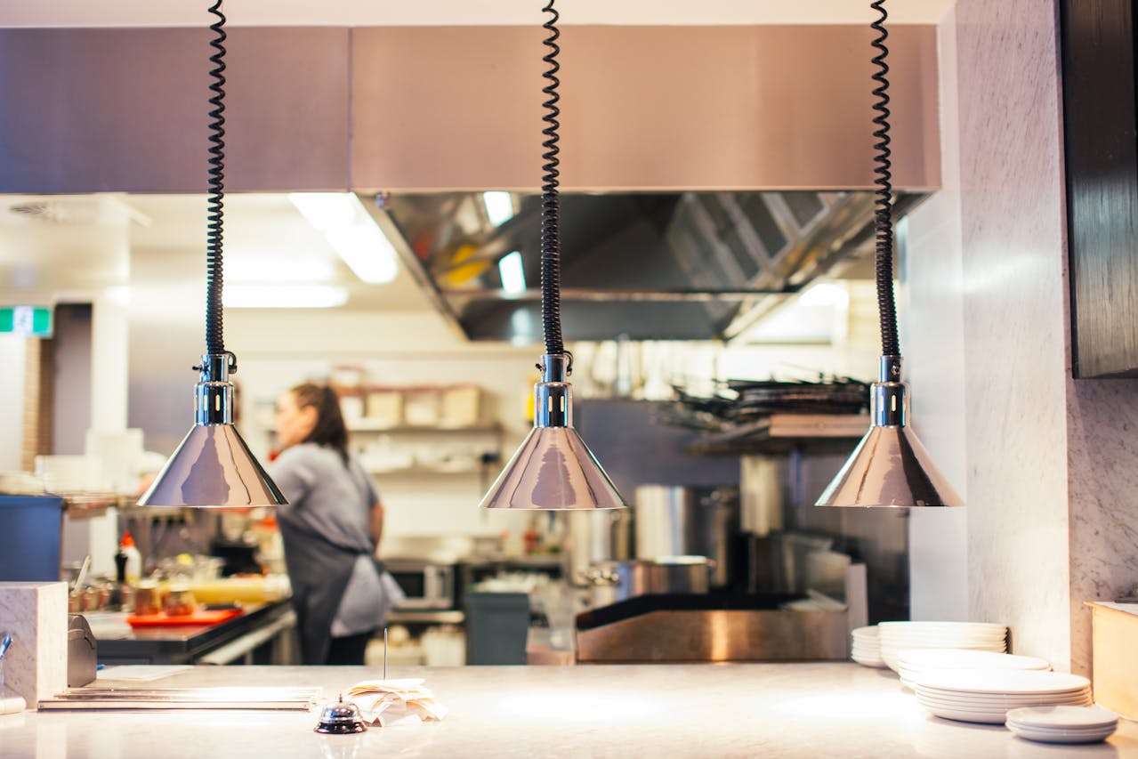 Soft focus kitchen as viewed from the pass, with hanging heat lamps