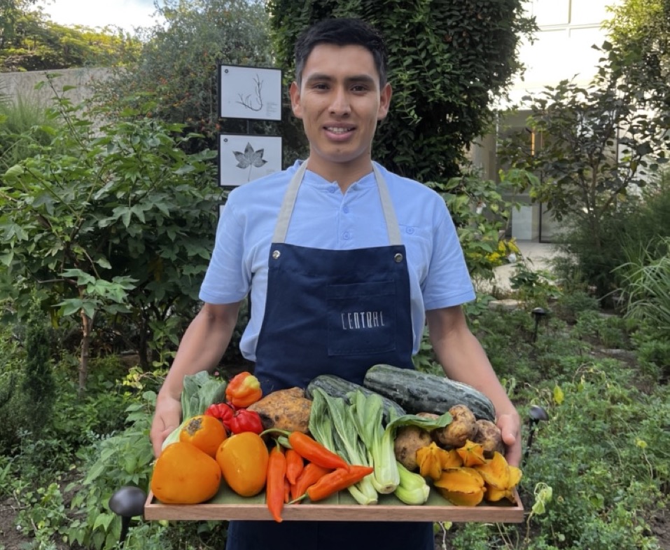 Rafael Bayona Leon CENTRAL Restaurant outdoors, holding tray of fresh vegetables