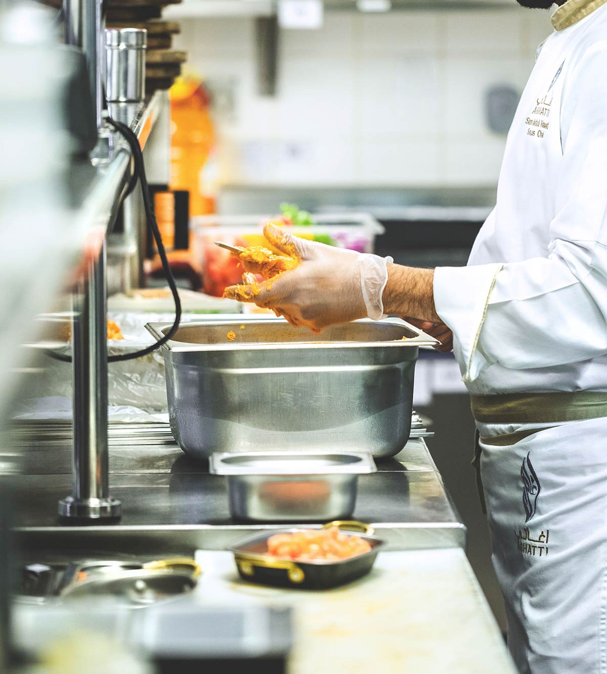 Chef preparing food in kitchen while wearing gloves