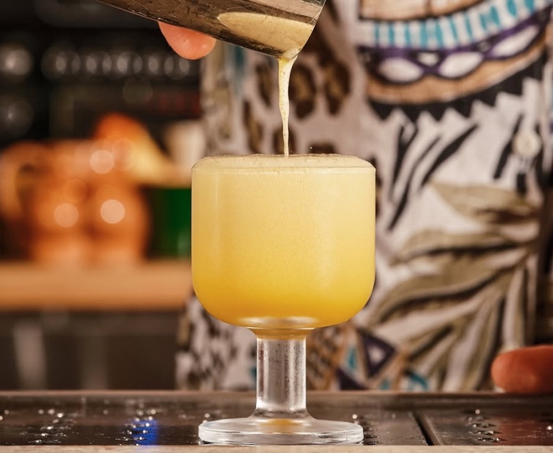 Yellow cocktail being poured into glass at Thunderbolt bar in Los Angeles